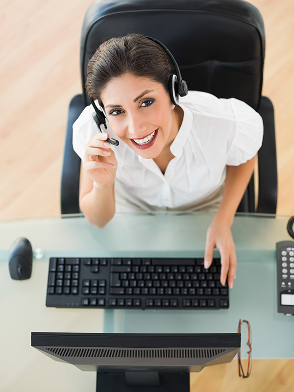 Cheerful call center agent looking at camera while on a call